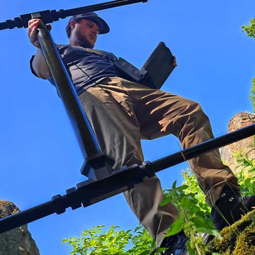 Person scanning with an OKM detector, with a clear blue sky and natural surroundings